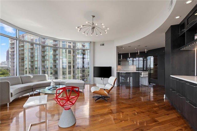 living area with a chandelier, expansive windows, and wood finished floors