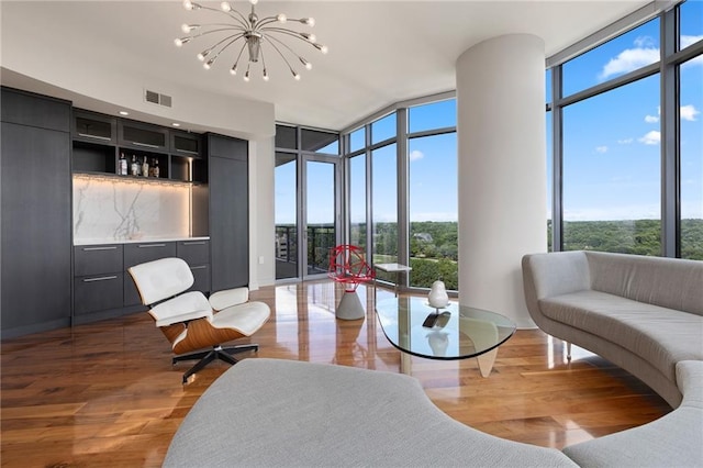 living room featuring floor to ceiling windows, a chandelier, and wood finished floors