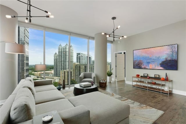 living room featuring plenty of natural light, expansive windows, wood-type flooring, and a notable chandelier