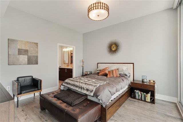 bedroom featuring light hardwood / wood-style flooring and ensuite bath