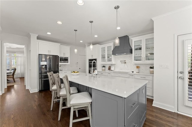 kitchen featuring stainless steel appliances, white cabinetry, custom range hood, dark wood finished floors, and crown molding