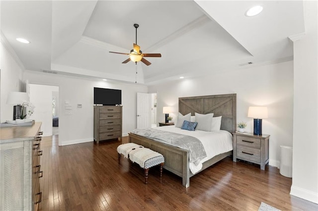 bedroom featuring a tray ceiling, dark wood-style flooring, visible vents, and crown molding