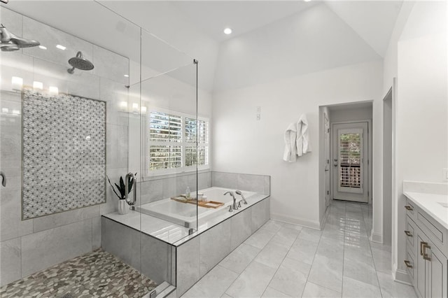 bathroom featuring lofted ceiling, tiled shower, plenty of natural light, and a garden tub