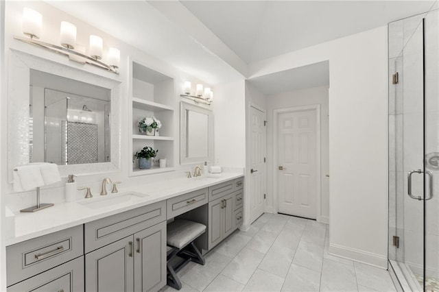 bathroom with baseboards, double vanity, a sink, and a shower stall