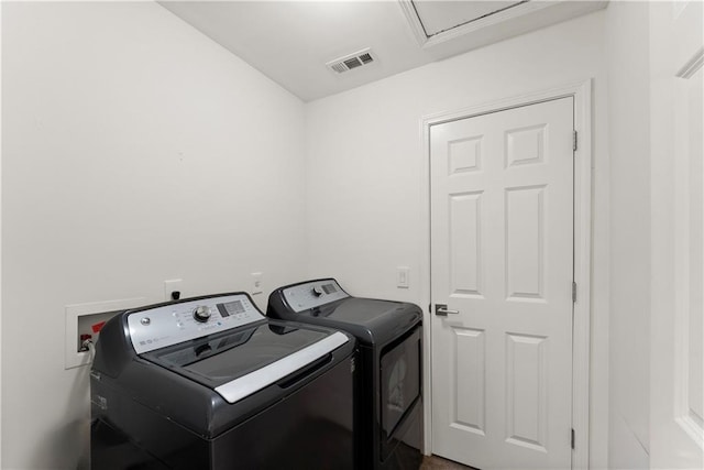 clothes washing area with laundry area, visible vents, and independent washer and dryer