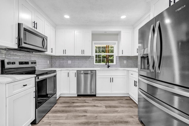 2089 Christian Cir SE, Conyers, GA 30013 - kitchen featuring stainless steel appliances, white cabinetry, recessed lighting, backsplash, and light wood finished floors