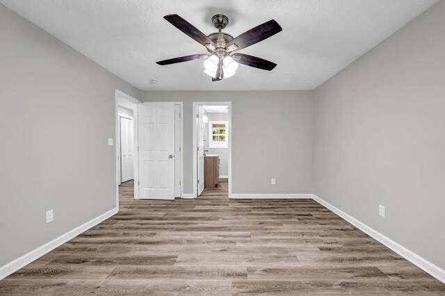 2089 Christian Cir SE, Conyers, GA 30013 - unfurnished bedroom featuring wood finished floors, ensuite bath, and a ceiling fan