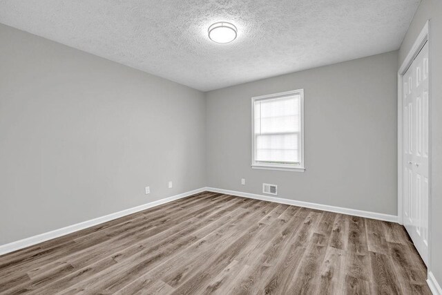 2089 Christian Cir SE, Conyers, GA 30013 - unfurnished bedroom featuring a closet, wood finished floors, and a textured ceiling