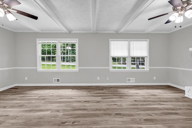 2089 Christian Cir SE, Conyers, GA 30013 - unfurnished room featuring ceiling fan, healthy amount of natural light, wood finished floors, beam ceiling, and a textured ceiling