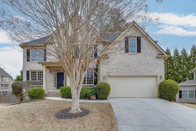 view of front of home featuring driveway, a garage, and brick siding