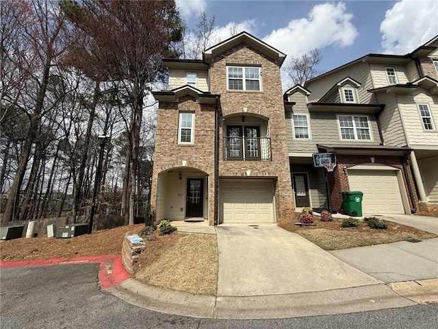 view of front of home featuring brick siding, an attached garage, concrete driveway, and a balcony