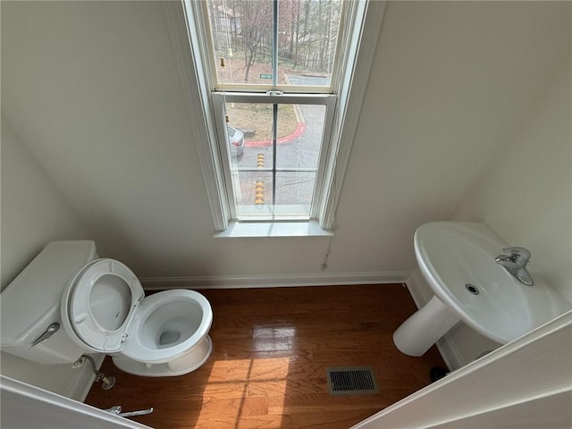 bathroom with toilet, wood finished floors, visible vents, and baseboards