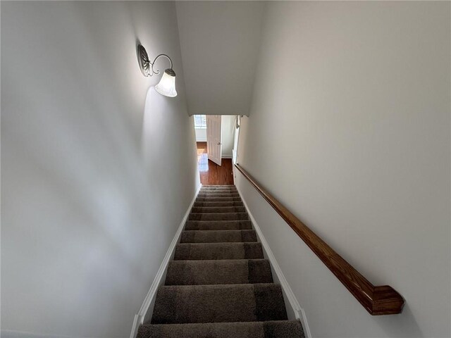 unfurnished bedroom with ensuite bathroom, light carpet, ceiling fan, and a tray ceiling