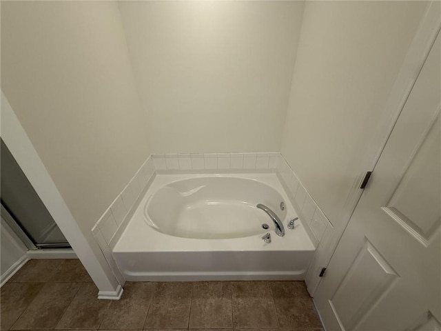 full bath featuring a garden tub and tile patterned floors