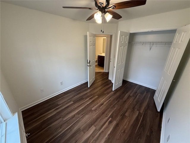 unfurnished bedroom featuring dark wood finished floors, a ceiling fan, baseboards, and a closet