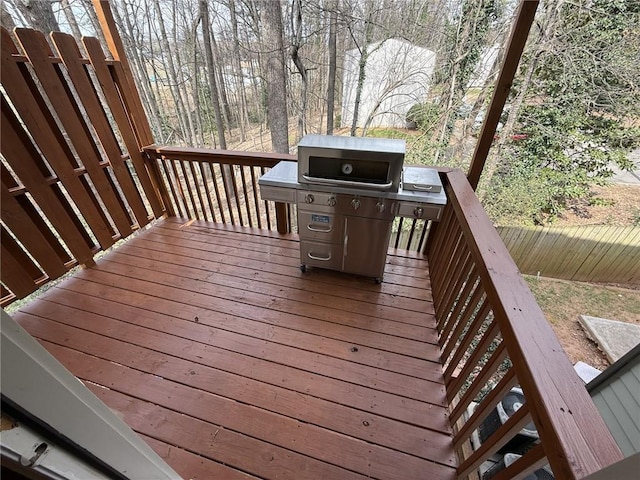 deck featuring grilling area and fence