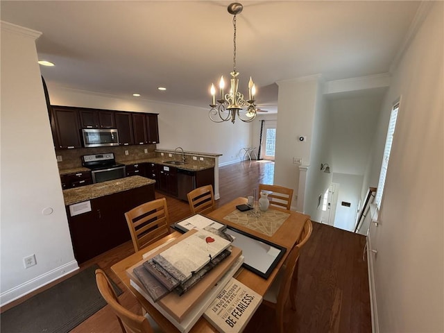 dining space featuring dark wood-style floors, baseboards, an inviting chandelier, recessed lighting, and ornamental molding