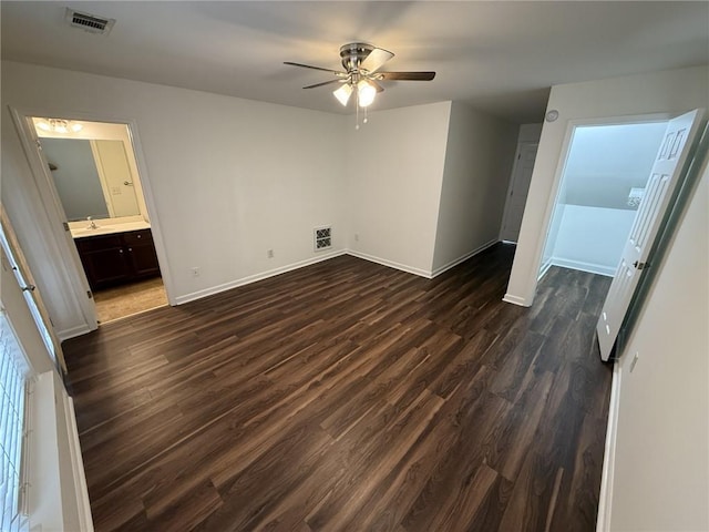 unfurnished bedroom featuring visible vents, baseboards, ensuite bathroom, and dark wood-style flooring