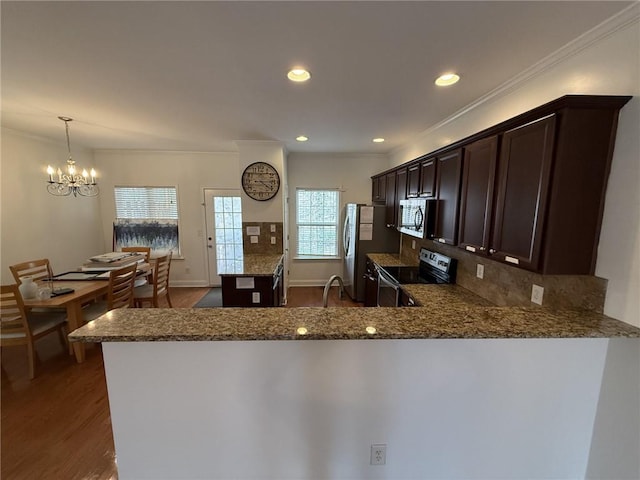 kitchen featuring dark stone countertops, decorative backsplash, dark brown cabinetry, stainless steel range with electric stovetop, and dark wood-type flooring