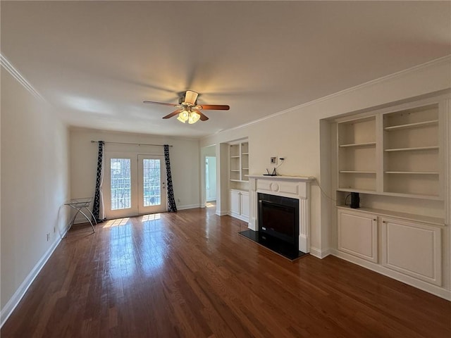 unfurnished living room featuring a fireplace with flush hearth, ornamental molding, built in features, dark wood finished floors, and baseboards