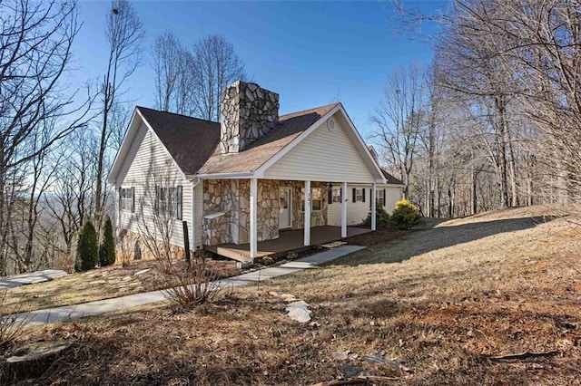 view of side of home with a porch and a yard