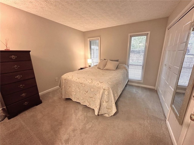 carpeted bedroom featuring a textured ceiling and a closet