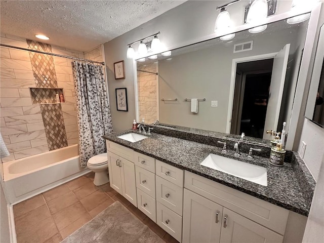 full bathroom with tile patterned floors, vanity, a textured ceiling, shower / bath combo with shower curtain, and toilet