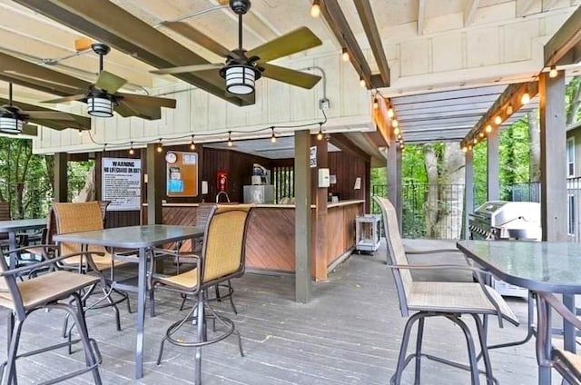 wooden terrace with ceiling fan and a grill