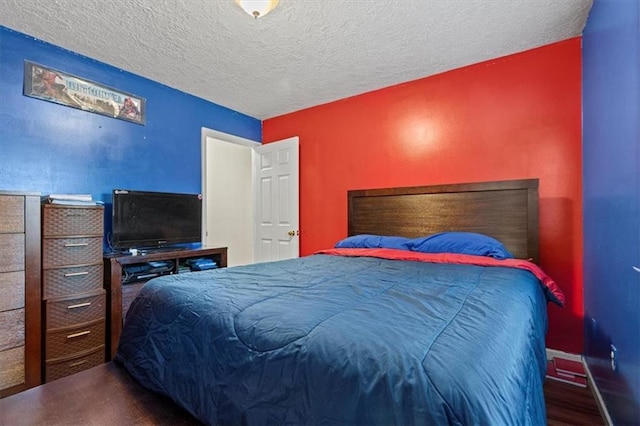 bedroom with a textured ceiling and hardwood / wood-style flooring