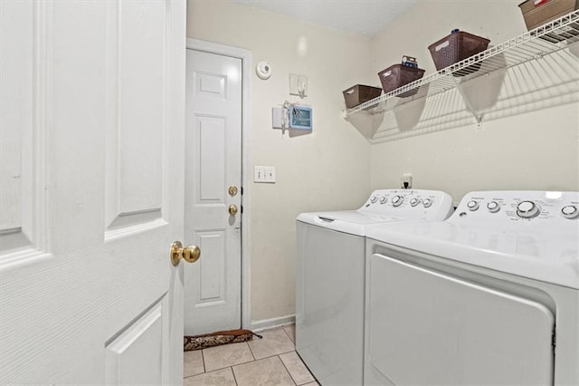 laundry room with separate washer and dryer and light tile patterned flooring