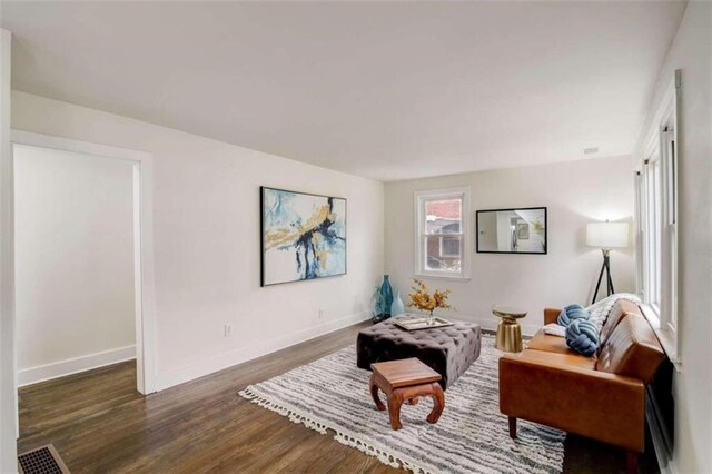 sitting room with dark wood-type flooring