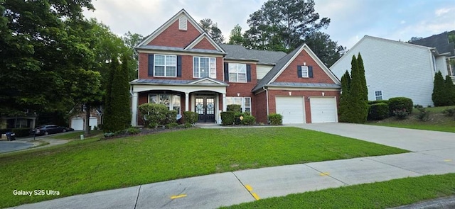 779 Avonley Creek Trce, Sugar Hill, GA 30518 - view of front of property with brick siding, concrete driveway, a front yard, and french doors