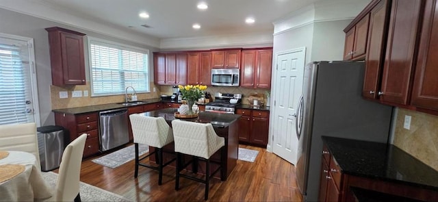 779 Avonley Creek Trce, Sugar Hill, GA 30518 - kitchen with stainless steel appliances, a sink, wood finished floors, reddish brown cabinets, and decorative backsplash
