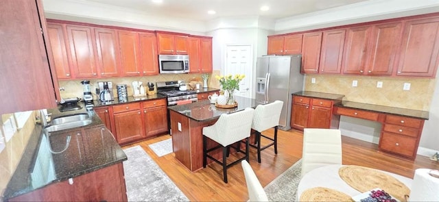 779 Avonley Creek Trce, Sugar Hill, GA 30518 - kitchen featuring stainless steel appliances, light wood-type flooring, a center island, a sink, and a kitchen breakfast bar