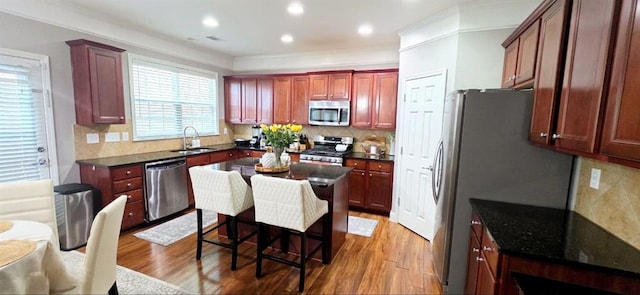 779 Avonley Creek Trce, Sugar Hill, GA 30518 - kitchen with appliances with stainless steel finishes, a sink, light wood-style floors, tasteful backsplash, and reddish brown cabinets