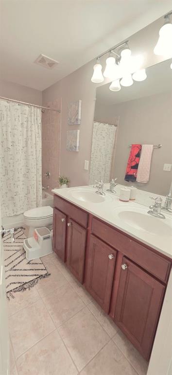 779 Avonley Creek Trce, Sugar Hill, GA 30518 - full bathroom with tile patterned flooring, double vanity, toilet, and shower / bathtub combination with curtain