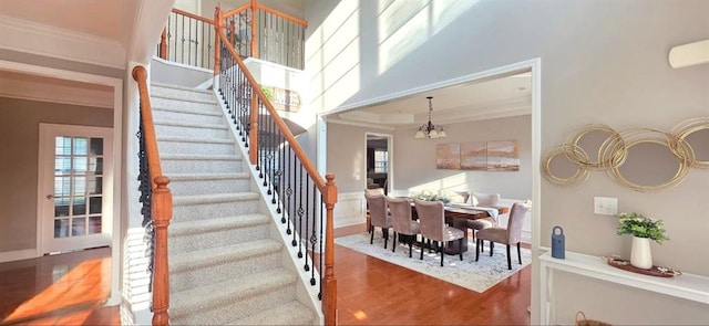 779 Avonley Creek Trce, Sugar Hill, GA 30518 - stairway featuring wood finished floors, a chandelier, crown molding, and a towering ceiling