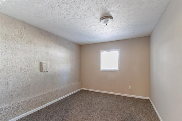 carpeted empty room with a textured ceiling