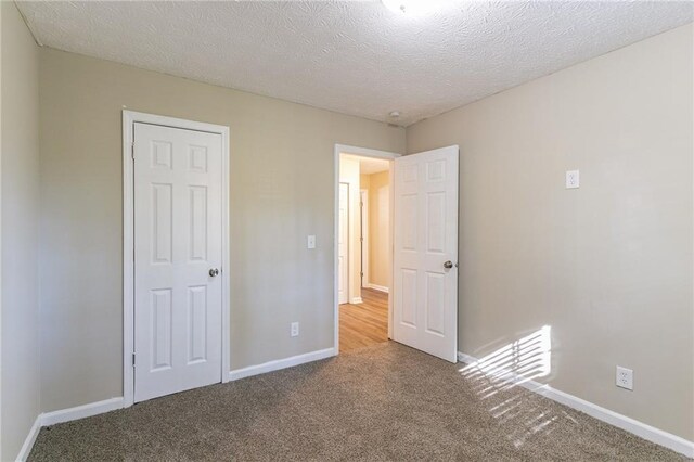unfurnished bedroom featuring carpet flooring and a textured ceiling