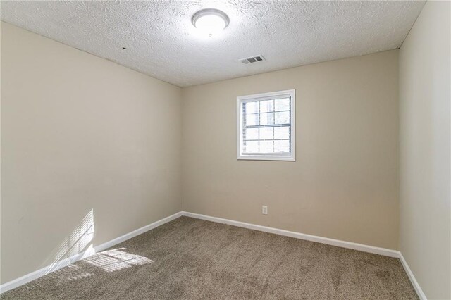 empty room featuring carpet flooring and a textured ceiling