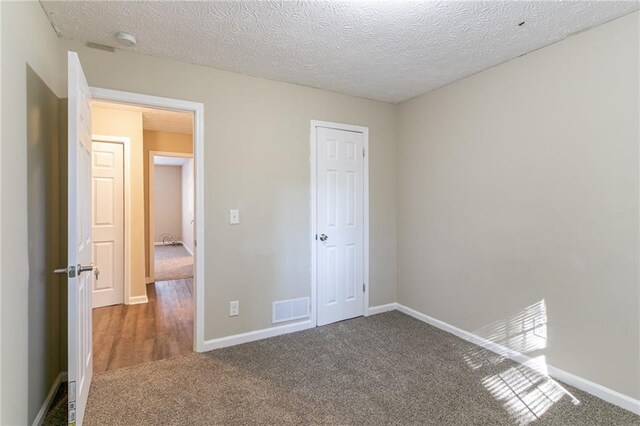 unfurnished bedroom featuring carpet flooring and a textured ceiling