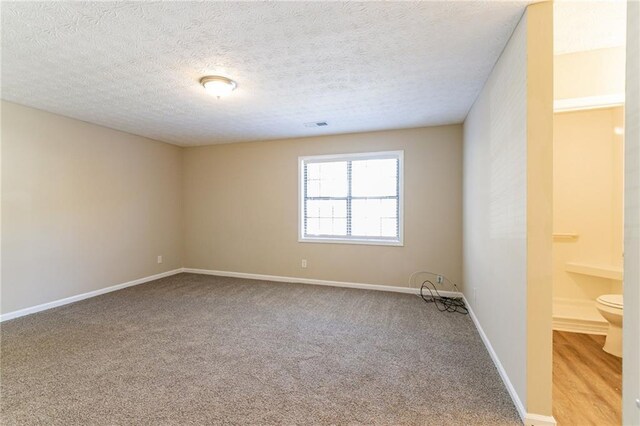 carpeted spare room featuring a textured ceiling