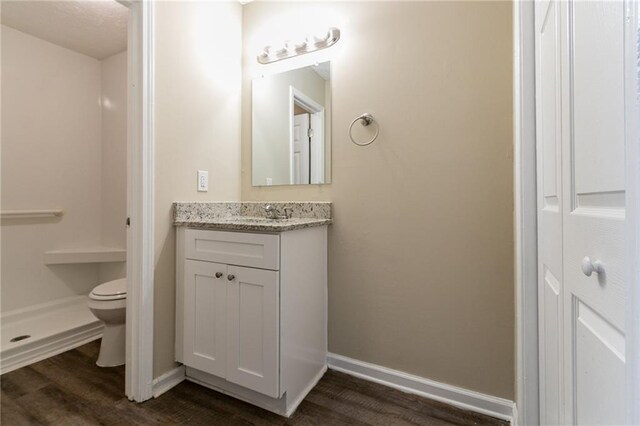 bathroom with hardwood / wood-style floors, vanity, and toilet
