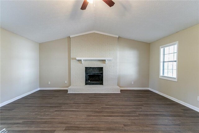 unfurnished living room featuring ceiling fan, dark hardwood / wood-style flooring, lofted ceiling, and a brick fireplace
