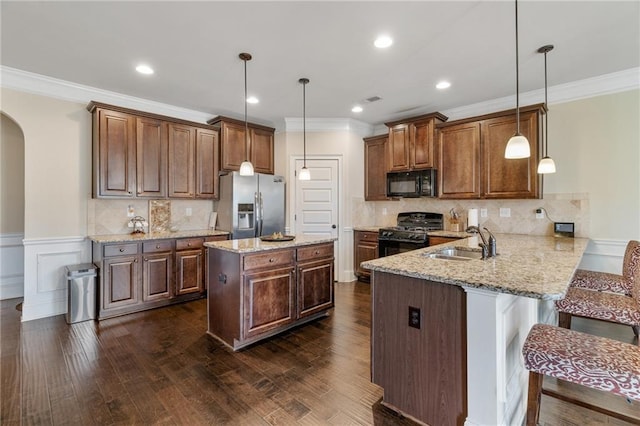 kitchen with black appliances, crown molding, arched walkways, and a sink