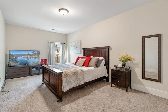 bedroom with visible vents, baseboards, and light carpet