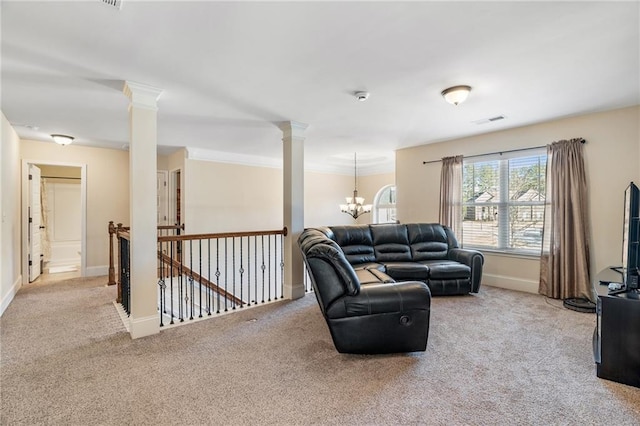 carpeted living room with visible vents, an inviting chandelier, baseboards, and ornate columns