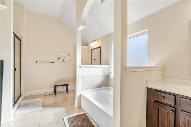 full bathroom featuring a shower stall, a garden tub, tile patterned flooring, and vaulted ceiling