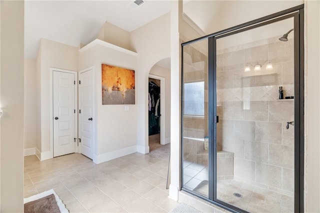 full bath featuring lofted ceiling, a shower stall, visible vents, baseboards, and tile patterned floors