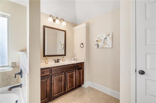 full bathroom featuring baseboards, a healthy amount of sunlight, a bathtub, and vanity